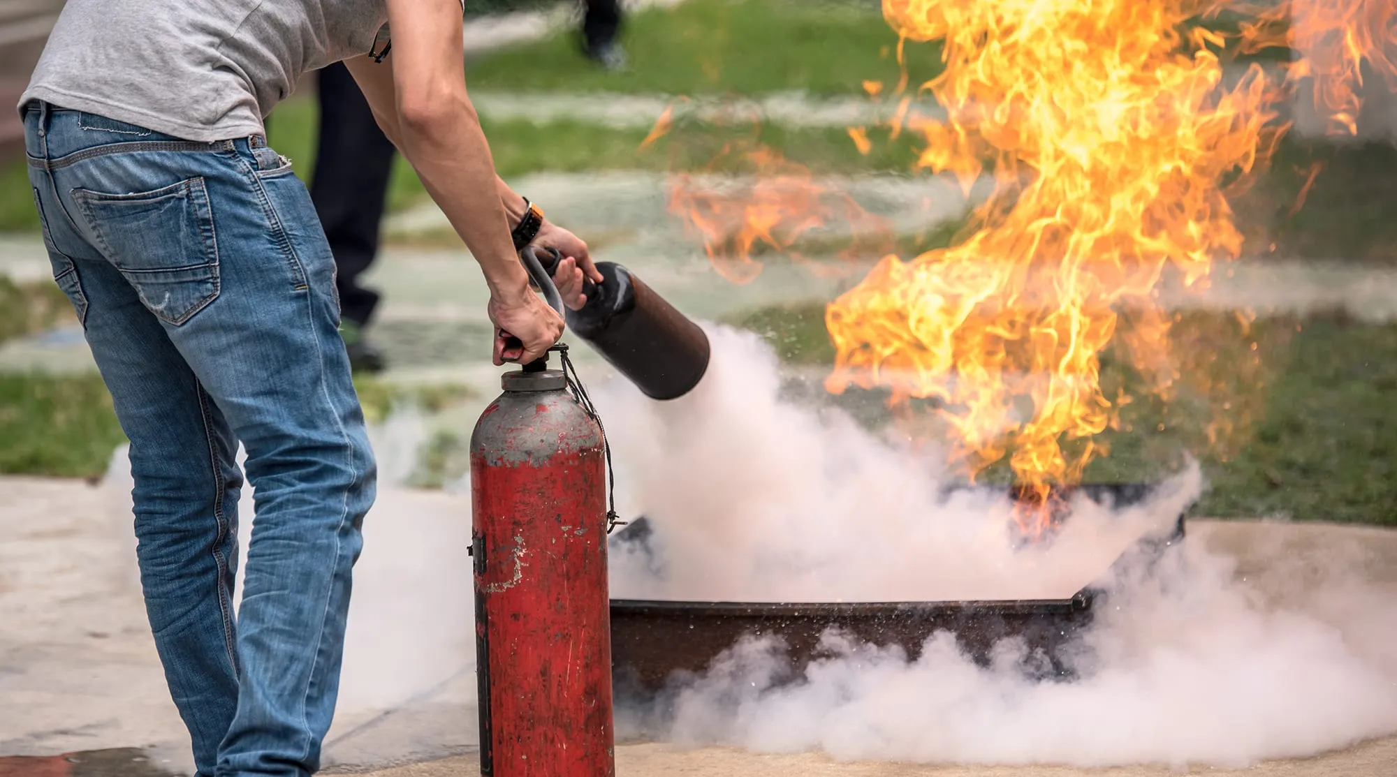 Exercice avec un extincteur face à un feu pendant une formation d'équipier de première intervention