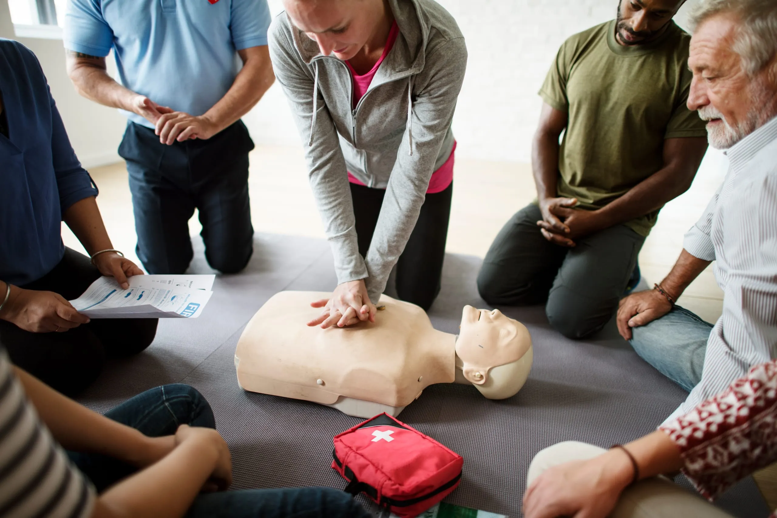 Participants pratiquant un massage cardiaque sur un mannequin de secourisme