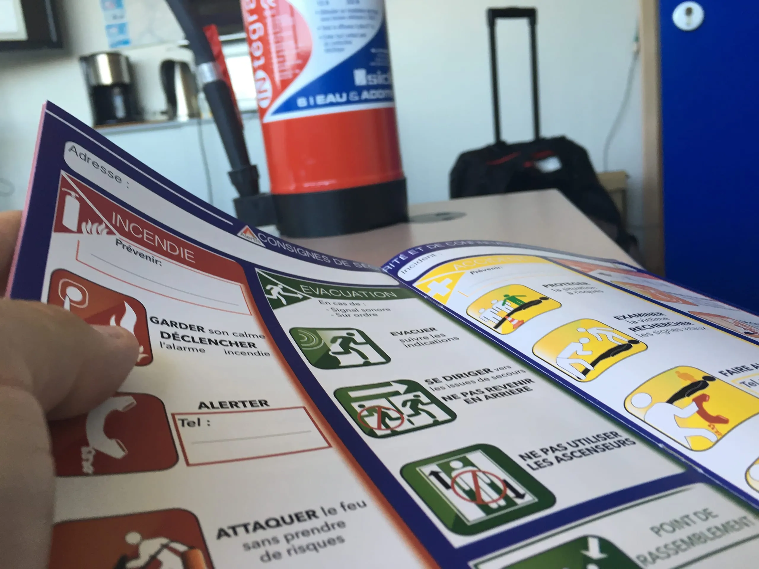 Support de formation ouvert sur les consignes d'incendie et d'évacuation, avec un extincteur