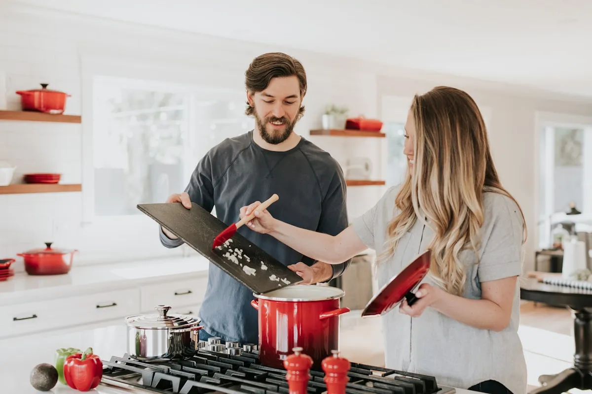 Deux personnes préparant des aliments dans une cuisine, contexte de formation à l'hygiène alimentaire et aux bonnes pratiques HACCP