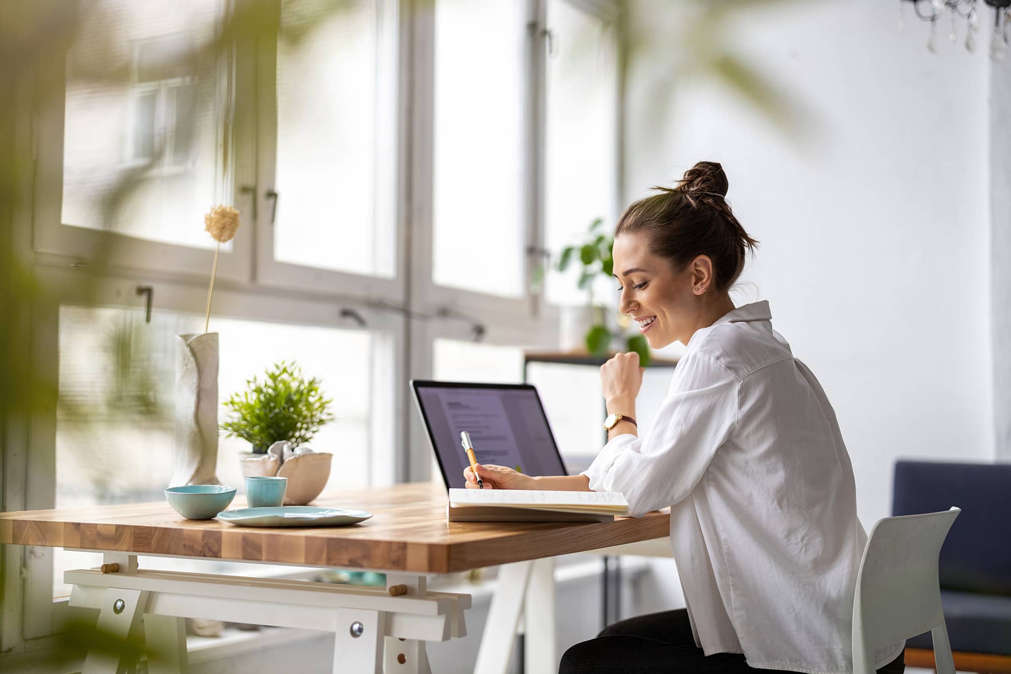 Cette image représente une femme sur son bureau avec son ordinateur